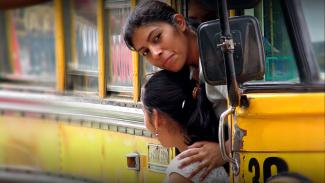 Woman and child peering out of a bus