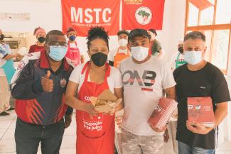 Photo of a group of 4 of people wearing facemasks, demonstrating food and books